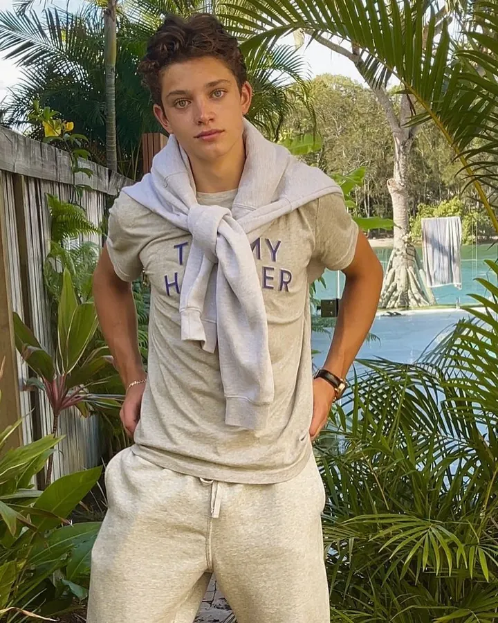 Homme en tenue de sport, posant devant une piscine, sweat sur les épaules