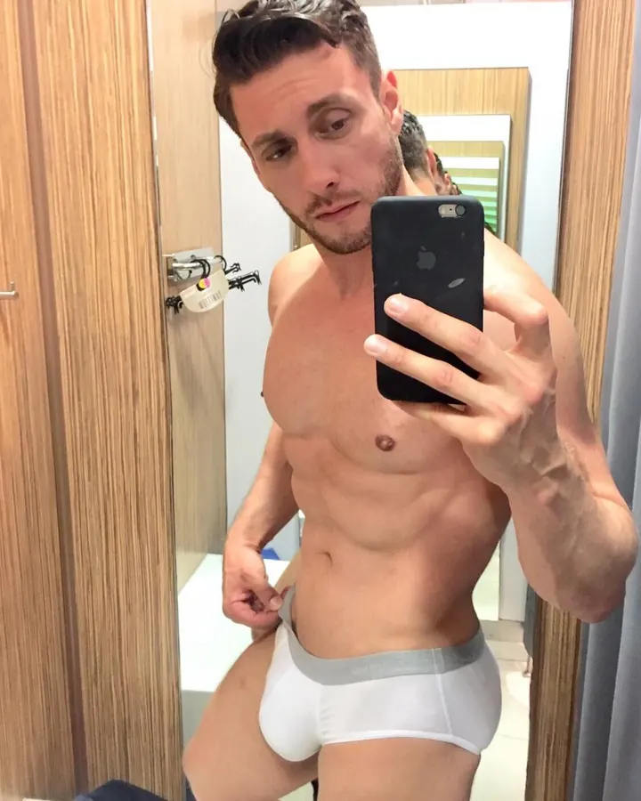 Homme torse nu, regardant dans un miroir, portant des sous-vêtements blancs dans une salle de bain