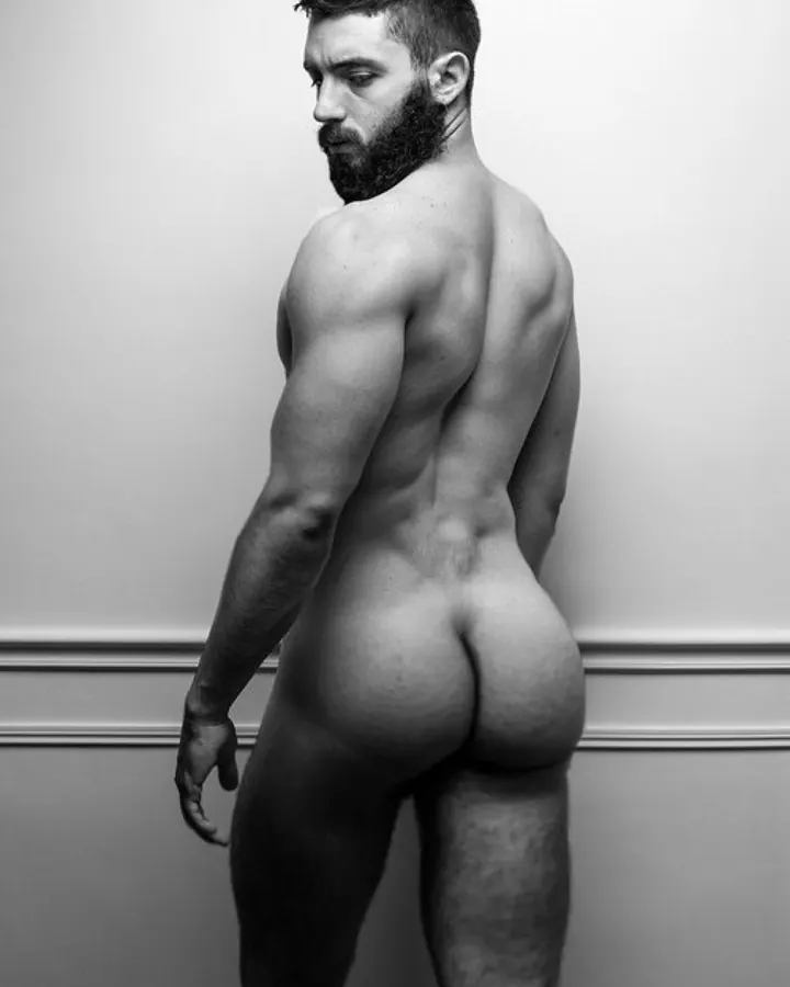 Homme nu de dos, regardant vers le côté, devant un mur blanc