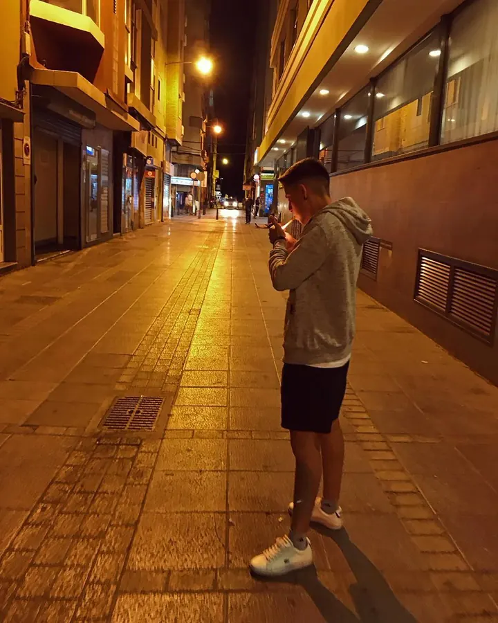 Homme torse nu, regardant l'appareil photo, main sur le ventre, en extérieur.