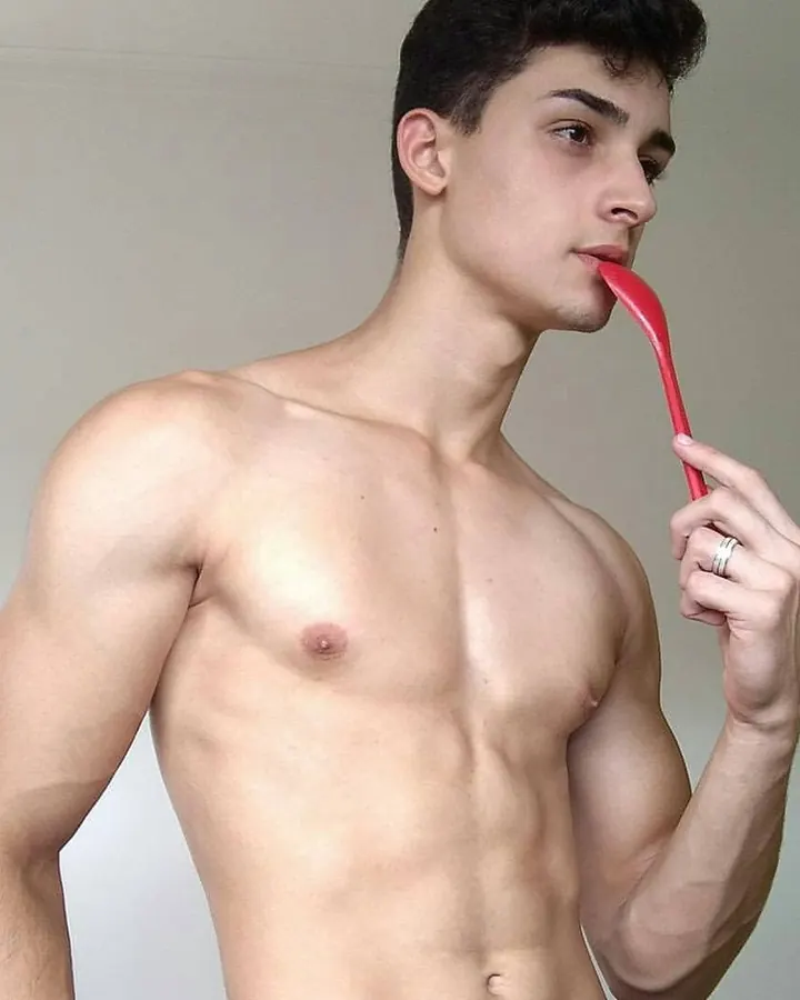 Jeune homme aux cheveux bruns, torse nu, regardant directement l'appareil photo