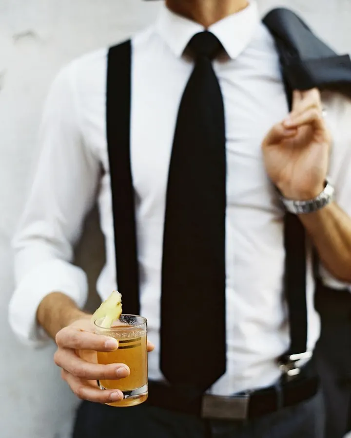 Homme torse nu, cheveux bruns, regardant directement l'objectif, dans un cadre sombre